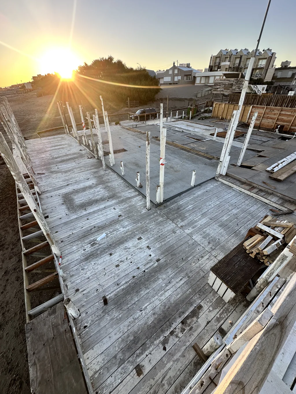 Sol bajo sobre la estructura de SHANTI durante el desmontaje del 10 de abril, con postes y piso de madera.
