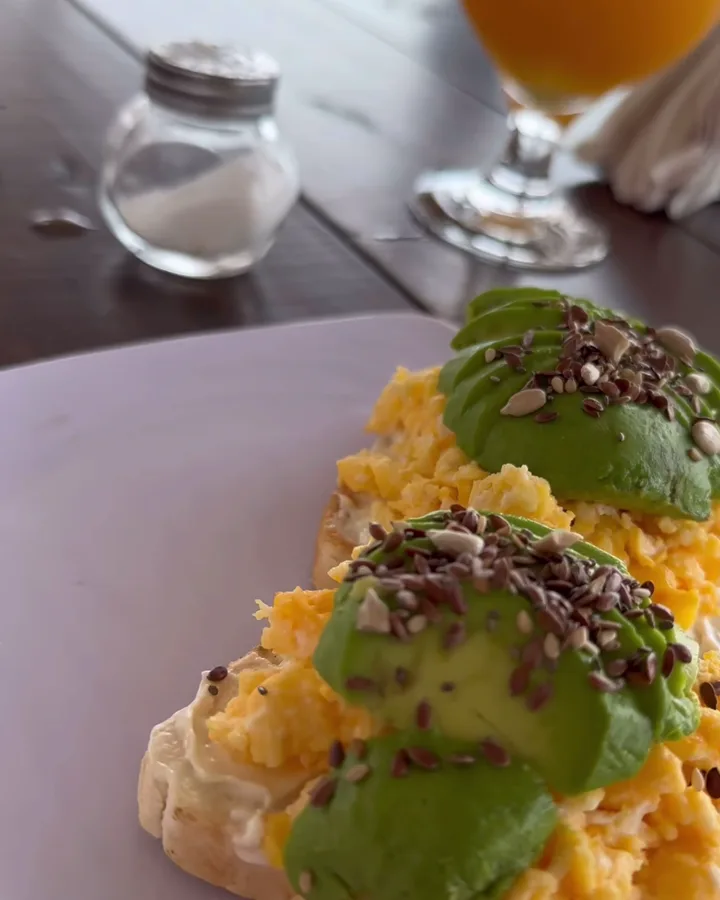 Video de archivo de una tostada con palta y huevo junto a un jugo